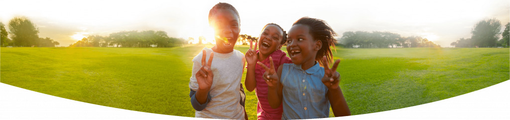 Happy children in a field making peace signs for the camera