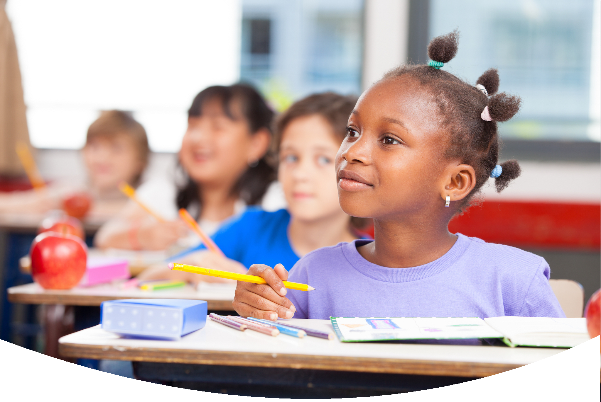 Attentive students at their desks looking up at teacher, ready to work