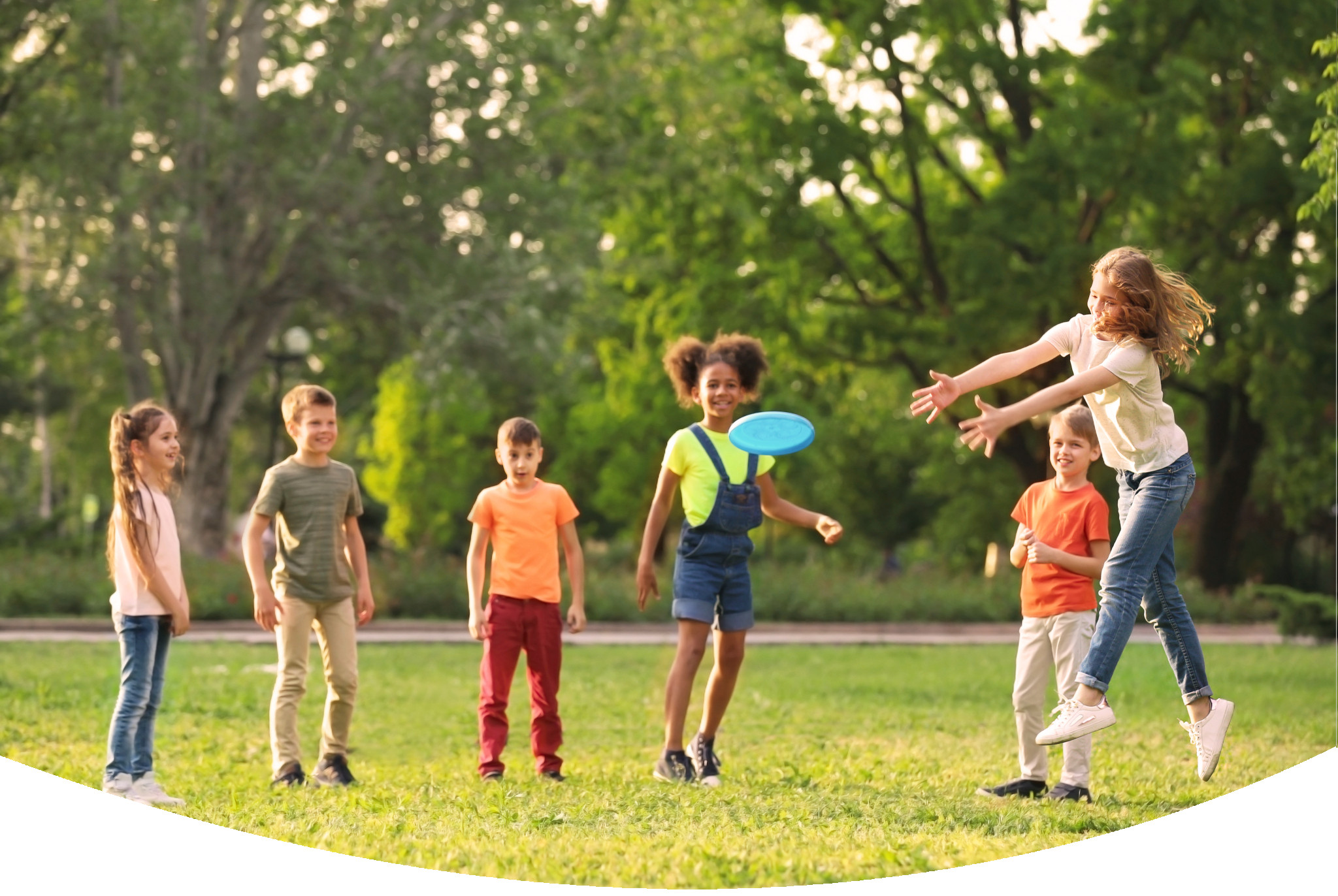 Happy children in a field playing Frisbee